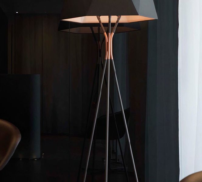 Floor lamp with metal base and shades in white or black fabric.